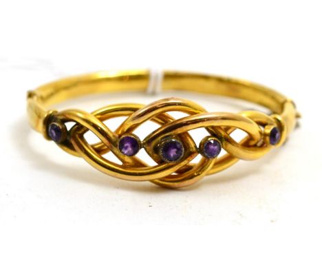 # An amethyst knot bangle, the entwined front section section with five round cut stones, hinged to a plain polished back, ca