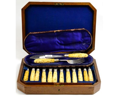 A set of twelve late Victorian fish knives and forks with silver blades and carved ivory handles in a fitted burr walnut case