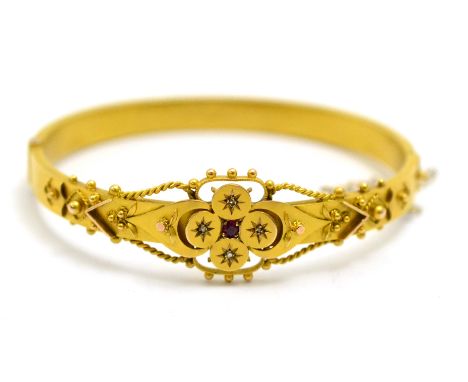 # A 9ct gold Victorian ruby and diamond bangle, the ornate ropework decorated and beaded front section hinged to a plain poli