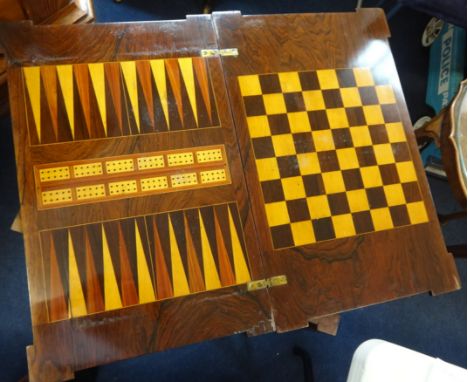 A late Victorian rosewood and inlaid games table with fold over top, decorated with a chessboard and backgammon complete with