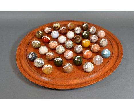 A Turned Wooden Solitaire Board together with a full set of semi precious stone marbles to include opal, quartz, jasper, and 