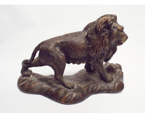 Bronze of a lion on a naturalistic modelled base signed Barrie 23cm long 