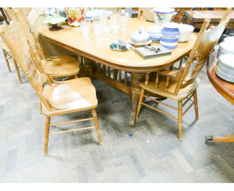 A large oak twin pillar extending dining table and 6 high backed matching chairs with panel seats