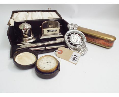 Brass cased aneroid barometer with leather outer case, Art Deco desk set in box, chrome automobile club bar badge and a conti