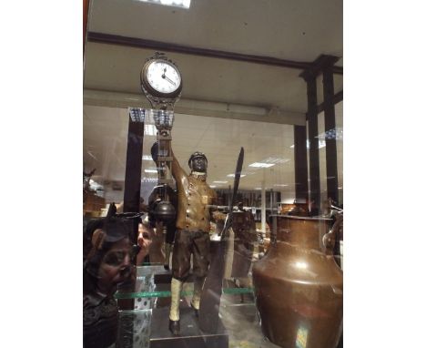 Cold painted bronze mystery clock modelled as a pilot holding a propellor, 38cm high overall 