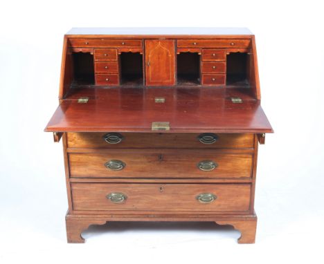 A GEORGE III MAHOGANY BUREAU the fall front with cross banded decoration and inlaid stringing opening to reveal a fitted inte