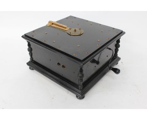 A PEERLESS PNEUMATIC ORGAN with winding handle and playing paper rolls and complete with retailers label for John G Murdoch a