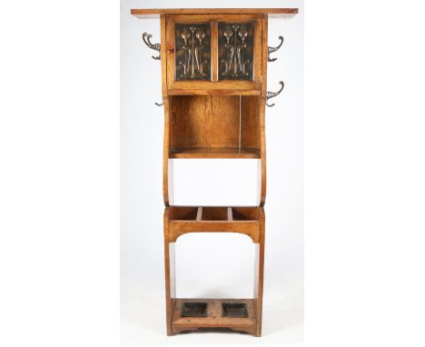 A LATE VICTORIAN OAK ARTS AND CRAFTS HALL STAND the single cupboard door with inset embossed copper panels with stylised flow