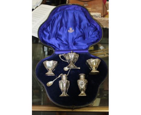 A HAMILTON & CO. SILVER CRUET SET with marks for London 1928 including a mustard pot with a blue glass liner, two salts and t