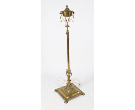 A VICTORIAN BRASS ADJUSTABLE LAMP STANDARD later converted for electric use with an octagonal column and spreading square bas