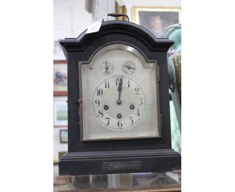 AN EARLY 20TH CENTURY JAPANNED GERMAN MANTLE CLOCK in a Georgian style case with arching top and carrying handle, the silvere