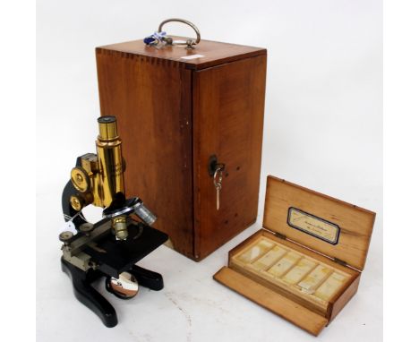 A STUDENT'S MICROSCOPE by Ernst Leitz with black lacquered stand, slide adjustment to the stage and with a reflector beneath 