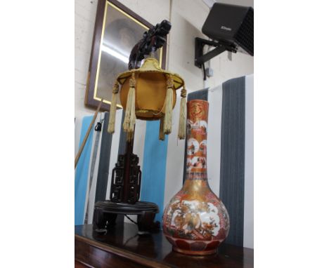 A SATSUMA WARE BOTTLE VASE with iron red ground and decorated with cartouches of figures on balconies and with 4 character ma