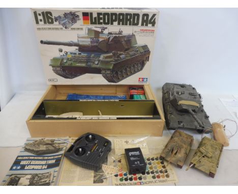 A Tamiya 1/16 scale German Leopard A4 Tank, a radio controlled kit (unchecked) and a box of parts. 