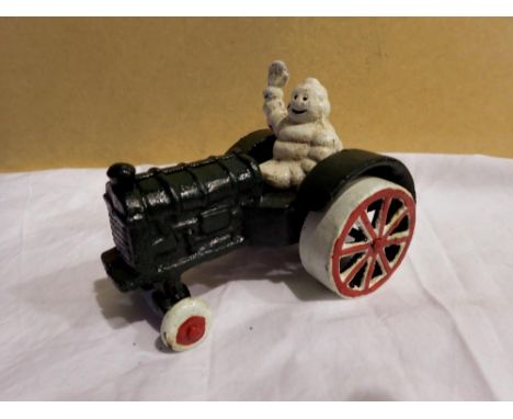 Cast iron Michellin Man on a tractor. H: 80 mm. UK P&amp;P Group 1 (£16+VAT for the first lot and £2+VAT for subsequent lots)