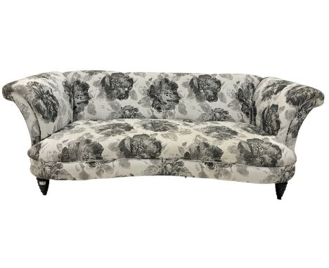 Three seat serpentine sofa, upholstered in natural floral fabric, raised on turned supports 