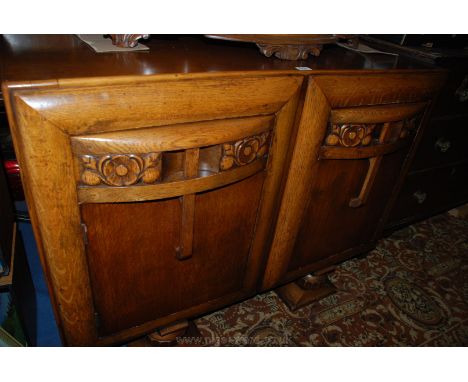 A 1930's Oak Sideboard, having upstand back and moulded top, having carved front drawer, over single panel cupboard door, sta