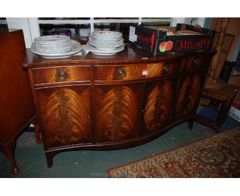 A reproduction Georgian style Mahogany finished serpentine fronted Sideboard having cross-banded serpentine top, over central