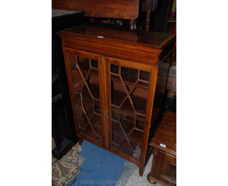 An Edwardian Mahogany glazed Cabinet having cross-banded moulded edge top over pair of opposing thirteen panel astragal doors