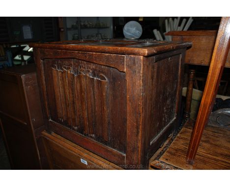 A circa 1920's Oak linen fold panel Coal Box having three panel lid with ornate iron 'H' hinges, single linen fold carved pan