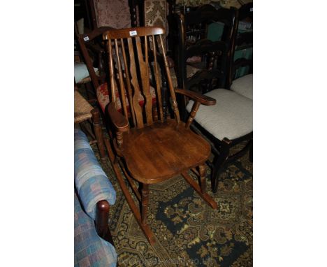 A modern Oak shaker style rocking Chair, twin slat and stick back, flat arms, shaped seat and turned legs.