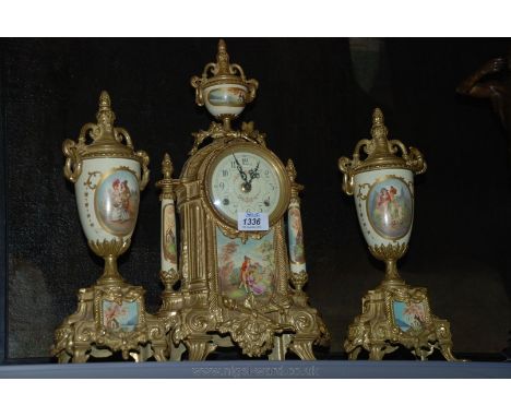 A French Mantle Clock, gold coloured with printed panel of a romantic garden scene, 45 cms tall with pair of matching Garnitu