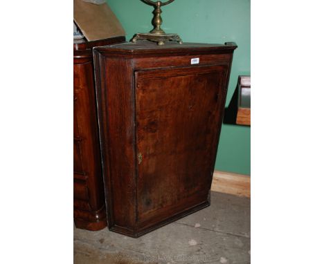 A 19th c. Oak wall hanging Corner Cupboard having moulded surround, single panel cleated top and bottom door opening to revea