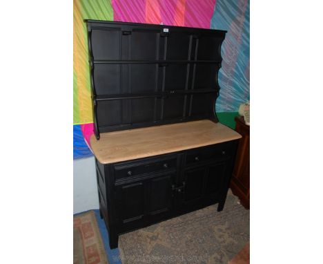 An Ercol style Dresser, painted black, the plate rack with two shelves and panel back sitting on the stripped top base, with 
