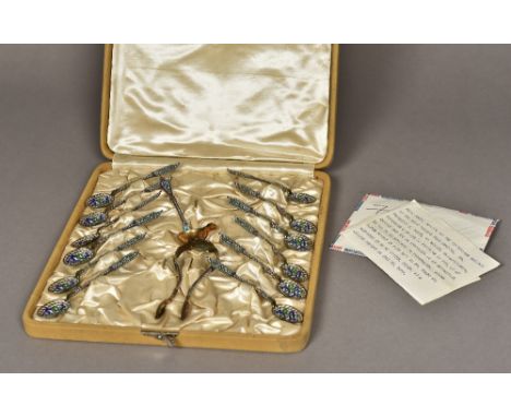 A Russian enamel decorated silver gilt coffee service
Comprising: twelve coffee spoons, a pair of tongs and a ladle, housed i