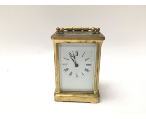 A french brass carriage clock. Circular dial with roman numerals.11cm x 7cm x 8cm