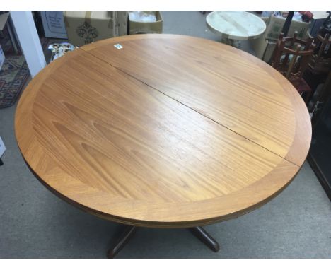 A modern teak dining table and four chairs. Table diameter approx 100cm.