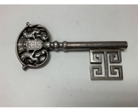 A silver Continental key corkscrew.