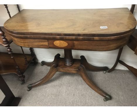 A Georgian mahogany card table the twin flap top above a turned column.