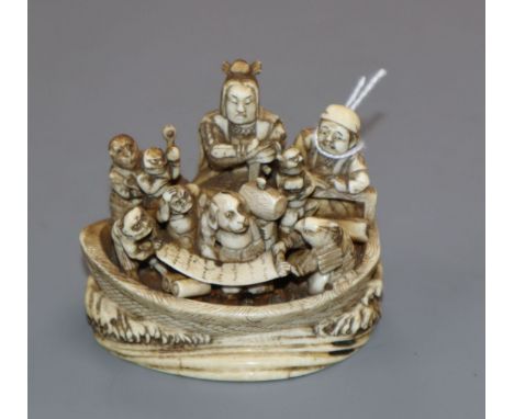A Japanese ivory okimono netsuke of a dog with a mallet