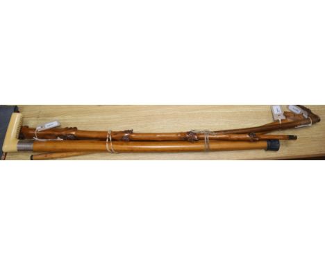 A fruitwood walking cane carved with multiple fox and dog masks and three other walking canes, including one with ivory grip 