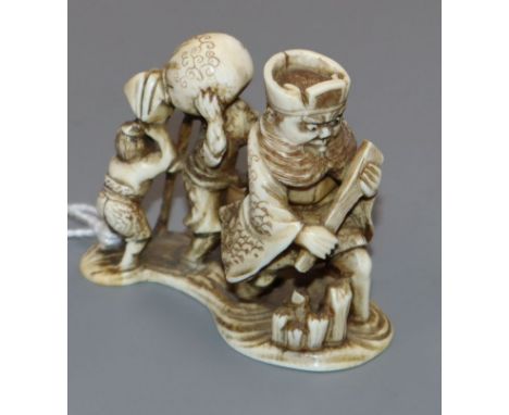 A Japanese ivory netsuke of four figures crossing the river