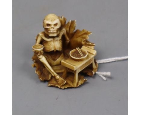 A Japanese ivory netsuke of a skeleton drinking sake