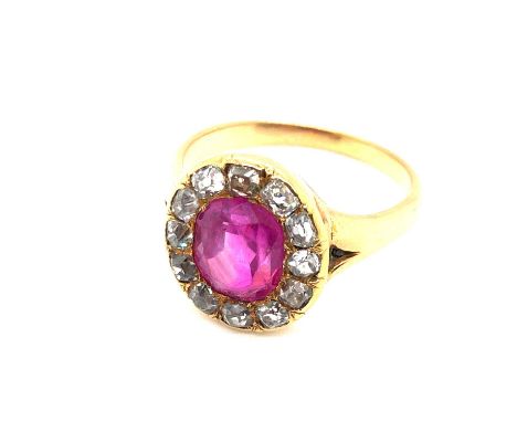 An antique ruby and old cut diamond cluster ring. The central oval ruby is surrounded by twelve old-cut diamonds. Unhallmarke