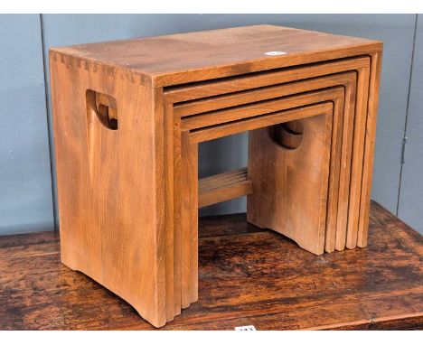 A nest of five Ercol oak tables, the uppermost with handles pierced into the plank sides. Height 40cms, Width 50cms, Depth 30
