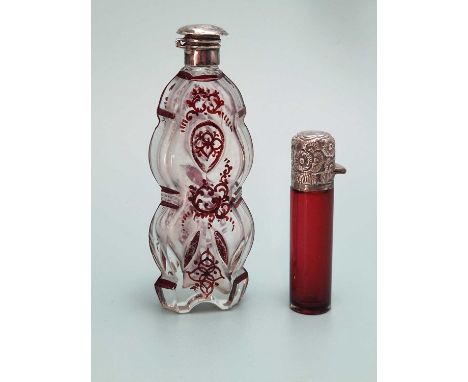 A ruby overlay clear glass scent bottle together with a cylindrical ruby glass scent bottle, both with silver tops