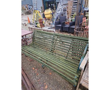 A large garden bench with green-painted iron scroll ends. 182cms long