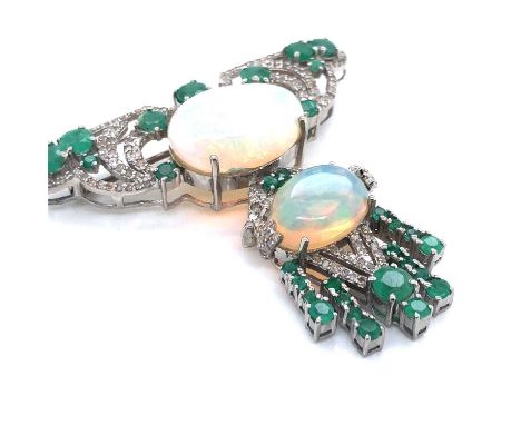 An Art Nouveau-style opal, emerald and diamond brooch. Unhallmarked, stamped 925, assessed as silver. The two cabochon opals 