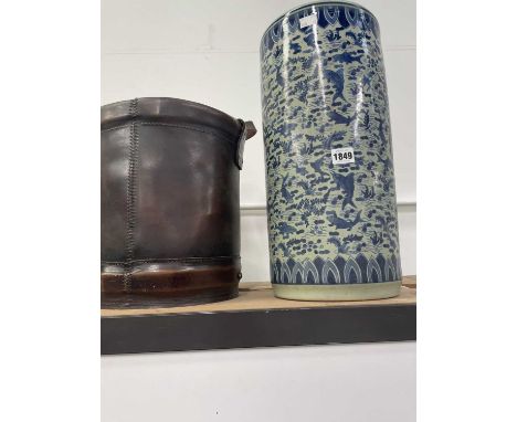 A Chinese blue and white cylindrical stick stand together with a brown leather bucket