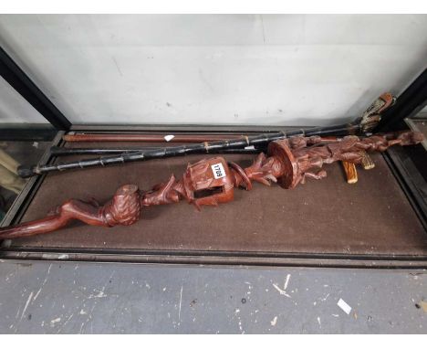 Two antler handled walking sticks, an ornately carved African walking stick together with a dog's head handled walking stick