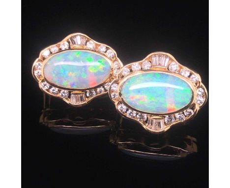 A pair of opal and diamond large stud earrings fitted with safety lever backs. The oval opals are surrounded by a cluster of 