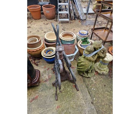A pair of cast iron bench ends and an iron pedestal.