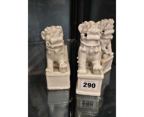 A pair and another blanc de Chine Buddhist lion, each seated by a jostick holder. H 12.5cms.