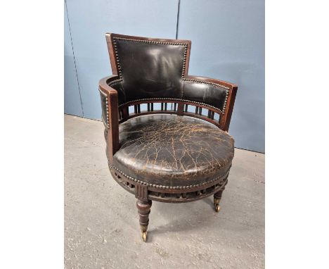 A mahogany tub armchair, the leather upholstered back and underarms above a balustrade of pairs of bars, the circular seat on