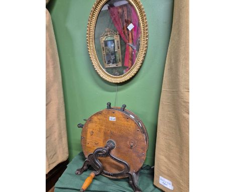 An urn topped gilt framed oval mirror, a Wetherburn knife cleaner, with three curtains