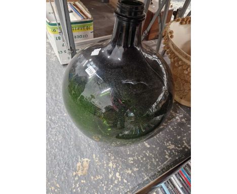 A green glass demijohn with its light fittings